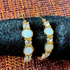 Gold tone with faux mother of pearl and diamond accent hoop earrings.